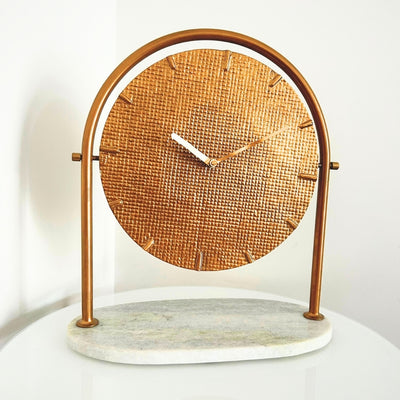 Reloj metálico redondo elegante sobre base de mármol con posibilidad de personalización mediante grabado